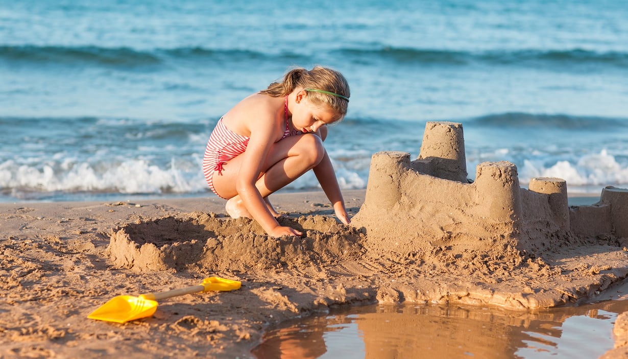 Jente bygger sandslott