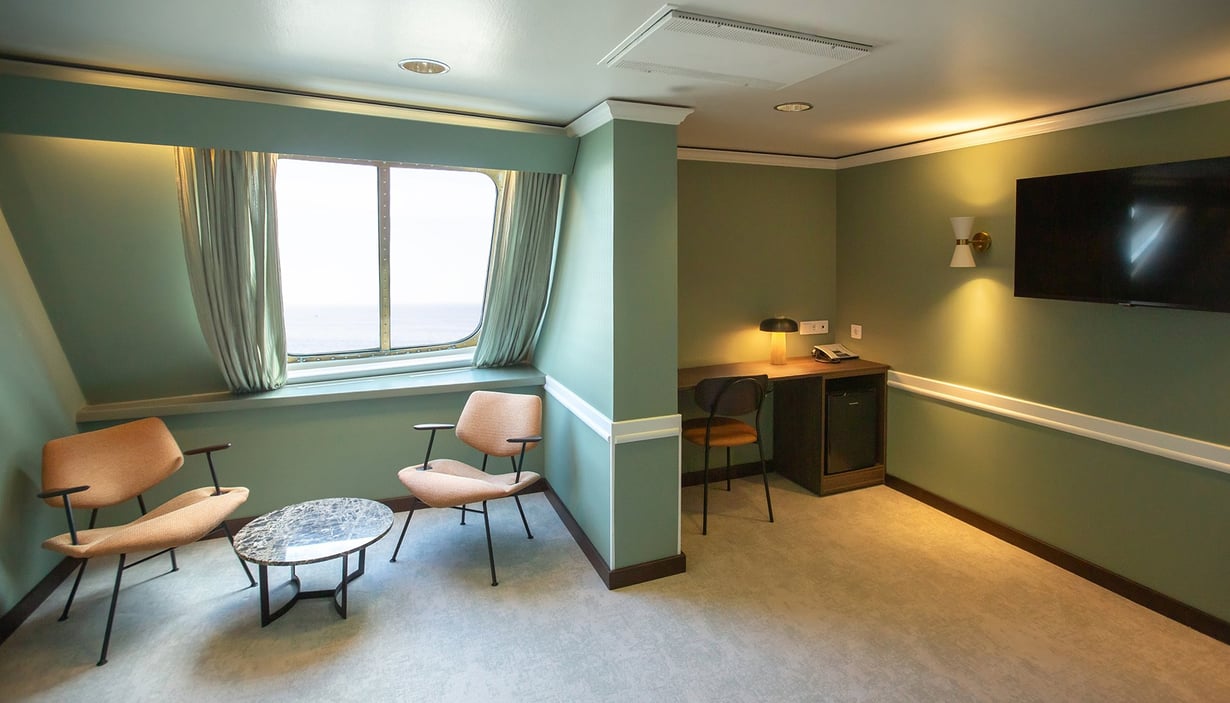 Moderne lugar med stoler, bord og flatskjerm-TV.