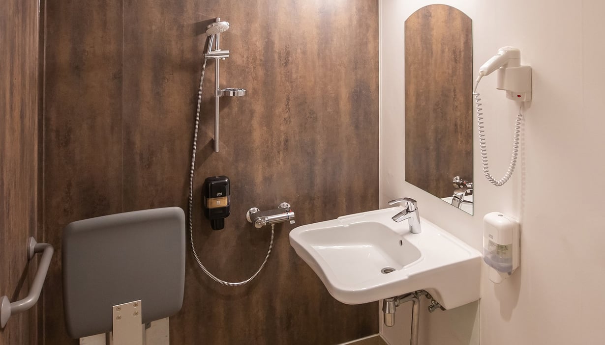 Handikapvennlig bad med vask og sammenleggbar dusjstol