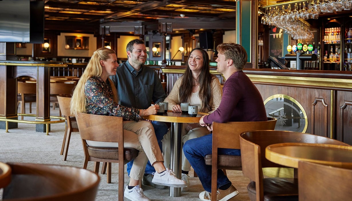 Folk sitter rundt et bord Anker Pub