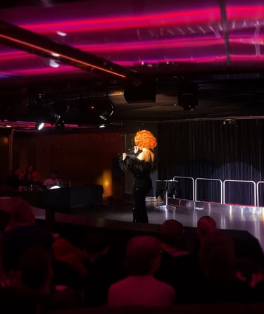 Utøver med krøllete parykk på scenen.