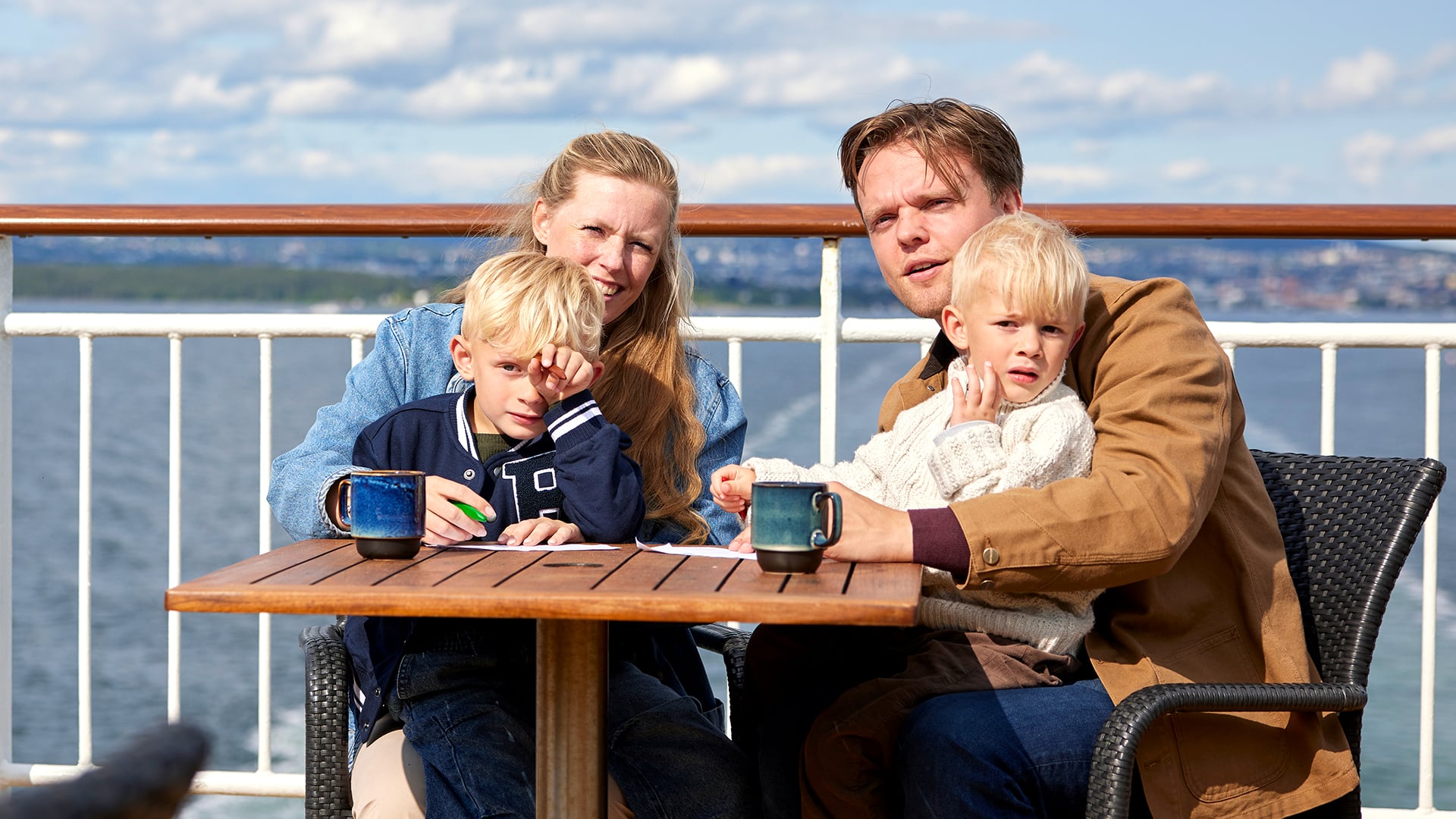 Familie nyter solen ute på dekk
