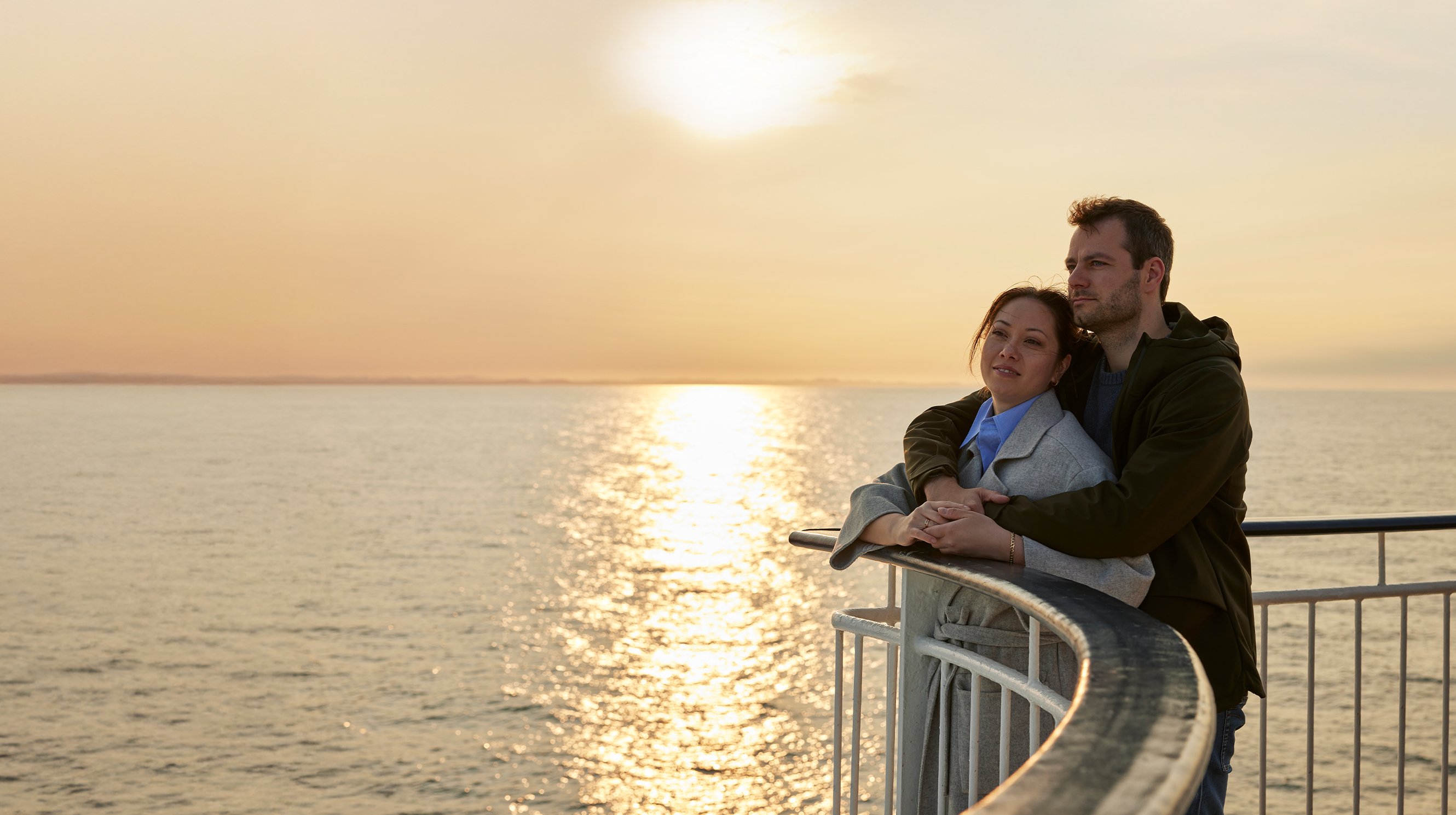 Par i solnedgang på dekk