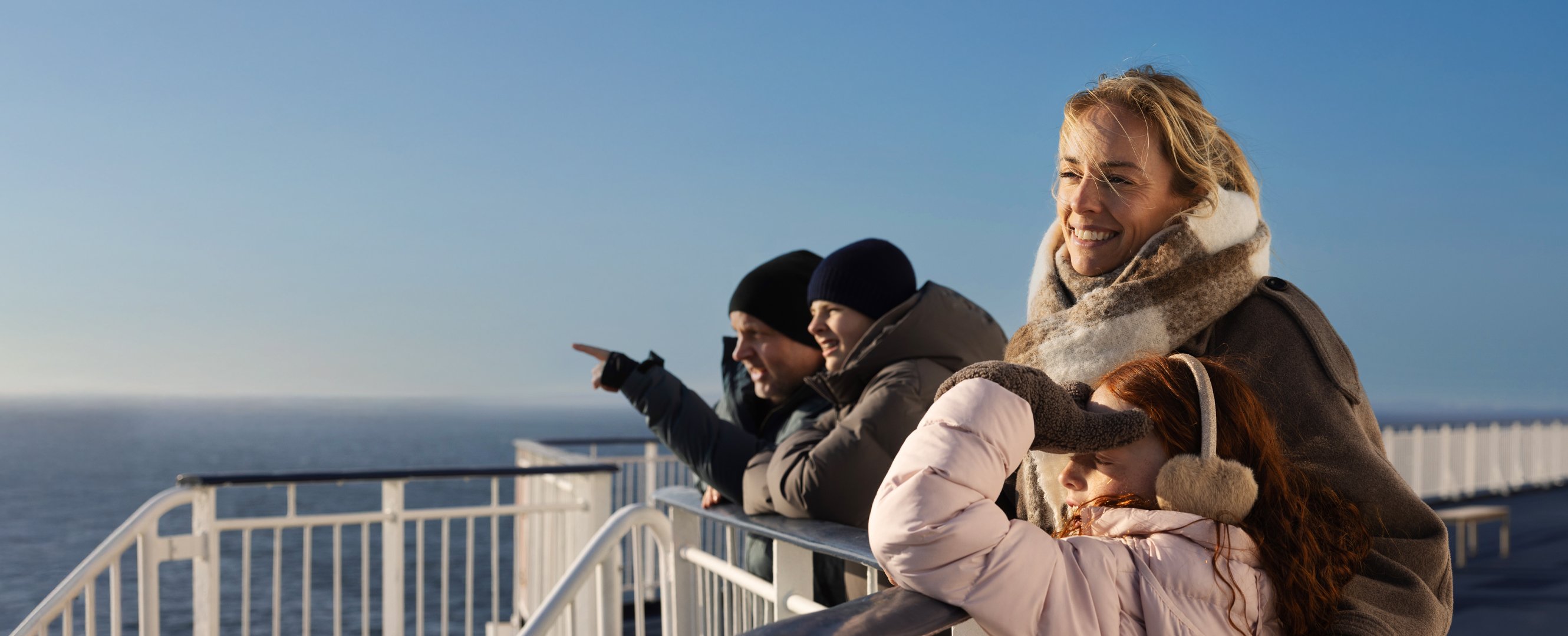 Familie ser utover havet fra dekk