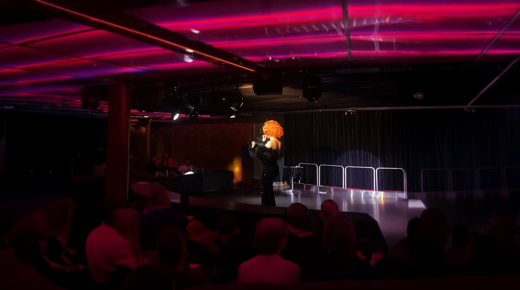 Utøver med krøllete parykk på scenen.