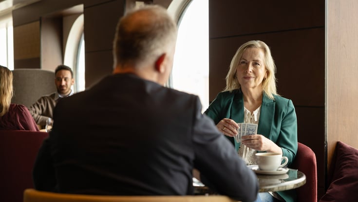 To personer som sitter ved et bord i en bar og spiller kortspill
