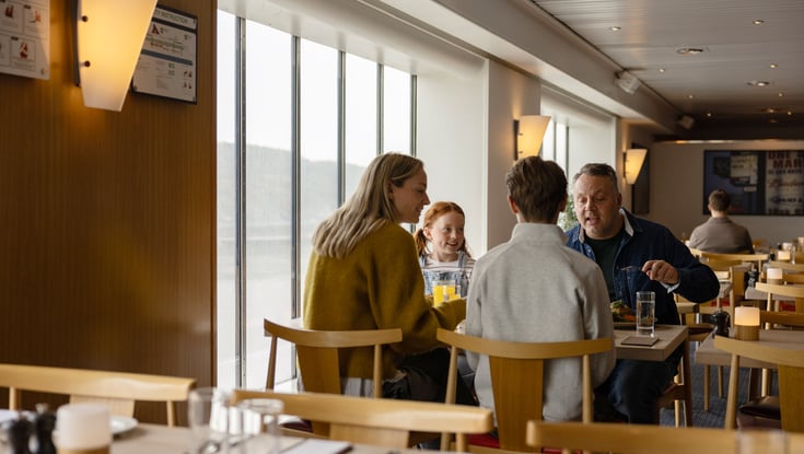 Gruppe mennesker som sitter ved et bord i en restaurant