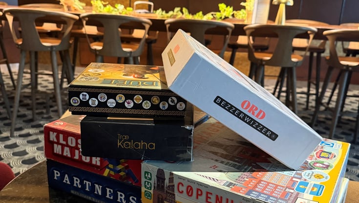 Stabel med brettspill på et bord i en kafé.