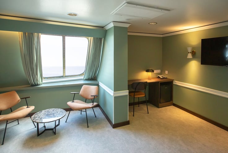 Moderne lugar med stoler, bord og flatskjerm-TV.