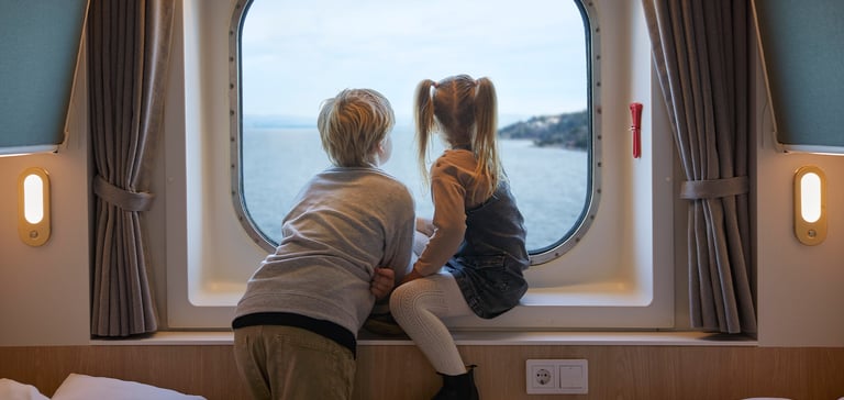 Gutt og en jente sitter i vinduskarmen på en lugar og ser ut