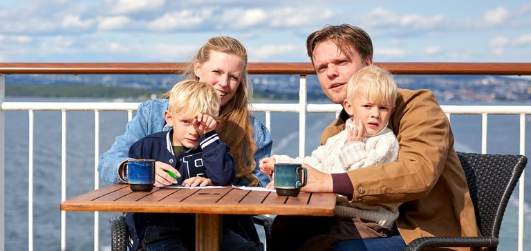 Familie nyter solen ute på dekk