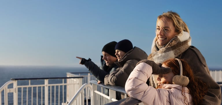 Familie ser utover havet fra dekk