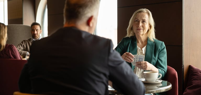 To personer som sitter ved et bord i en bar og spiller kortspill