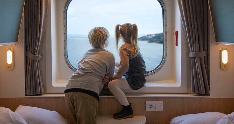 Gutt og en jente sitter i vinduskarmen på en lugar og ser ut