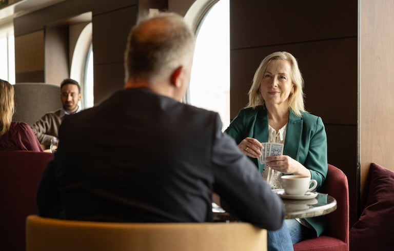 To personer som sitter ved et bord i en bar og spiller kortspill