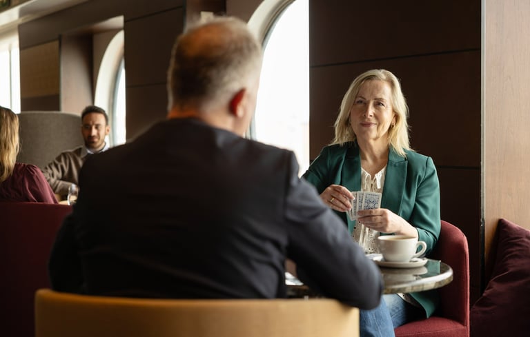 To personer som sitter ved et bord i en bar og spiller kortspill