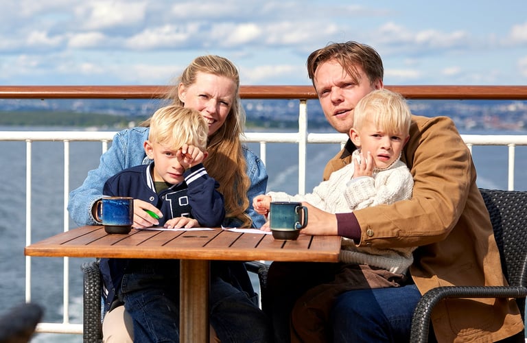 Familie nyter solen ute på dekk