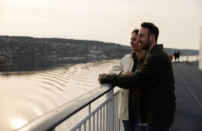 To personer som står på et dekk og ser ut over en vannmasse.