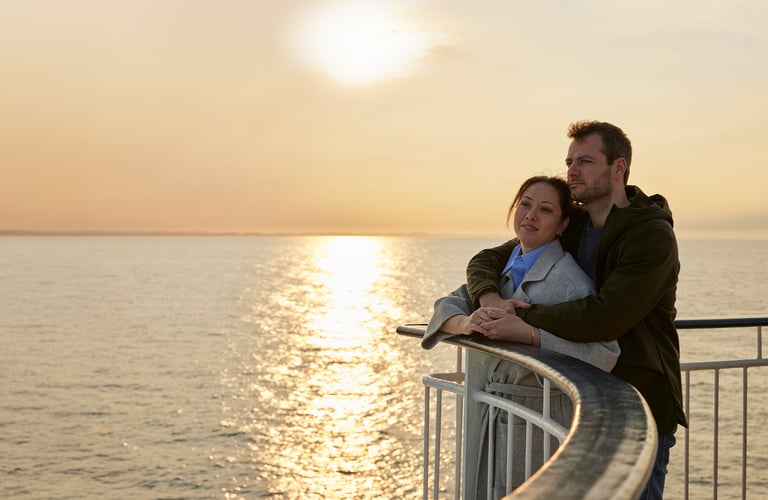 Par i solnedgang på dekk